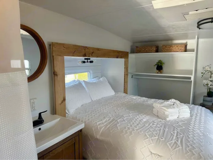 Modern RV rental interior: A bright bedroom featuring a comfy bed, sink, storage, & fresh white decor.. Forest River Sierra Sport 2007