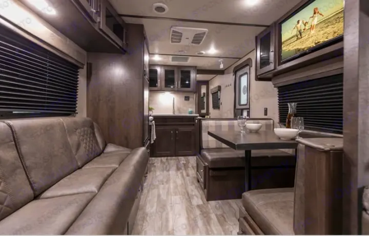 An RV rental interior showcasing a cozy living space with a comfortable sofa, a functional kitchen, and a dining dinette.. Grand Design Transcend Xplor 2022