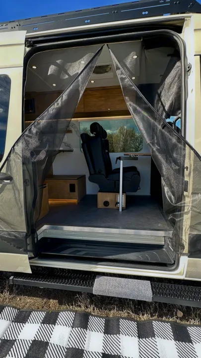 Inside an RV rental: a spacious mobile office with a comfy chair, table, and screen door, ideal for road trips.. Mercedes-Benz Sprinter High Roof Medium wheelbase 2021
