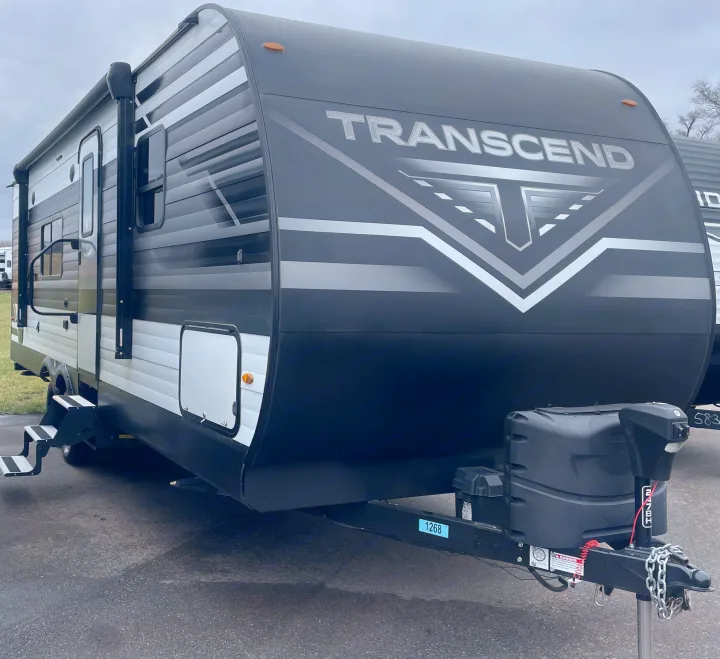 This modern black and white Transcend travel trailer is ready for your next rv rental trip, featuring a front hitch, steps, and awning.. Grand Design Transcend Xplor 2022