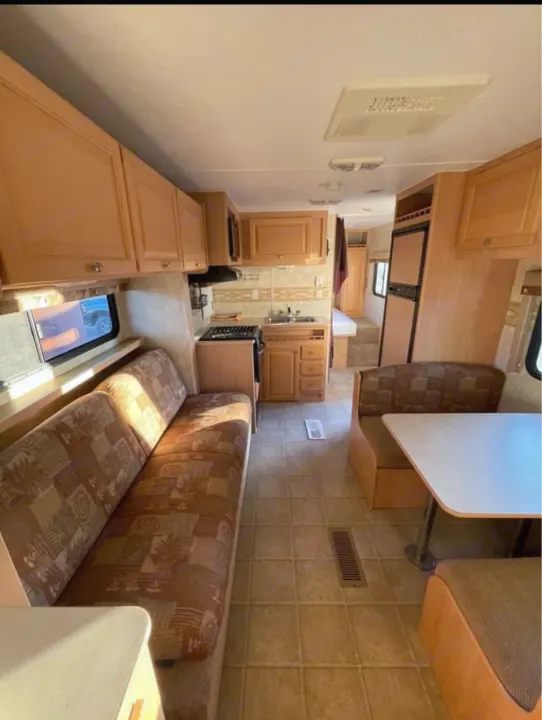Spacious RV rental interior with kitchen, long sofa, and dinette. Ideal for your next adventure.. Thor Motor Coach Wave 2007