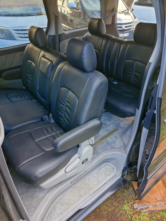 Luxurious black leather seating of an Alphard, offering spacious comfort for travel, like a premium RV rental.. Toyota Alphard 2024