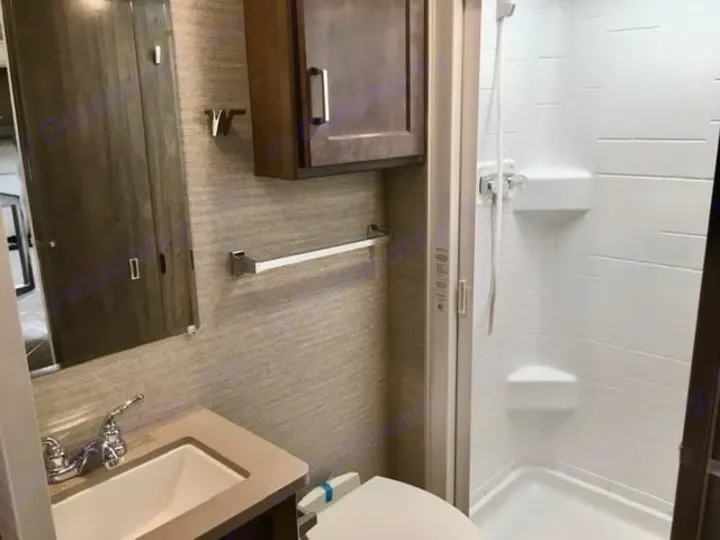 Compact RV rental bathroom, featuring a clean stand-up shower, sink vanity, and mirror.. Winnebago Minnie Winnie 2024