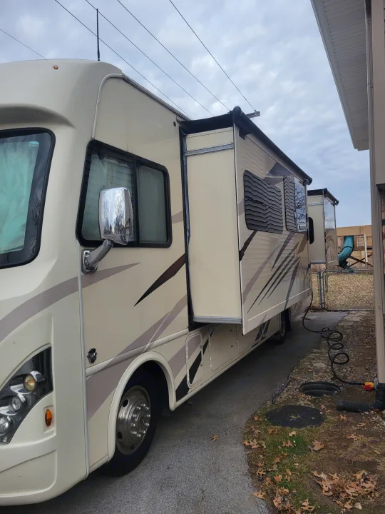 Cream-colored RV rental parked with slide-out and awning extended. Ready for your next travel adventure.. Thor A.C.E. 2018