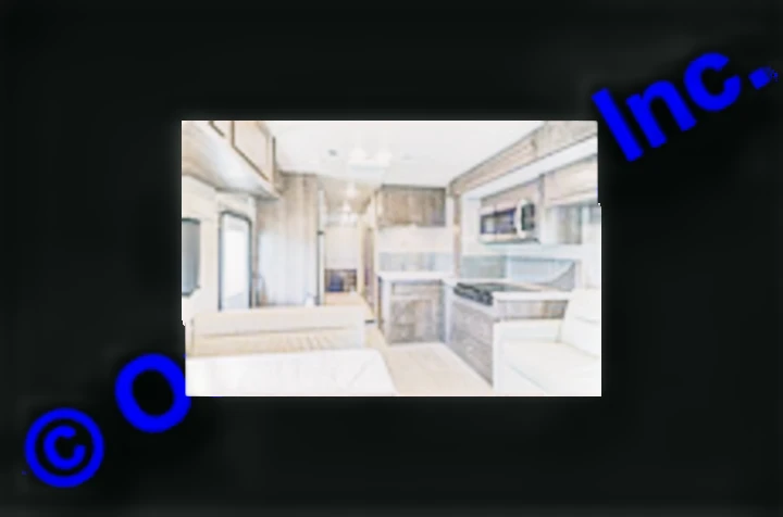 Inside a spacious RV rental, showing the modern kitchen with stove/microwave, dining, and living areas. Ideal for travel accommodation.. Nexus RV Triumph 2022
