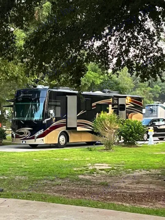 Luxury Venetian motorhome RV rental parked at a shady campground site with slide-outs extended.. Thor Venetian 2017