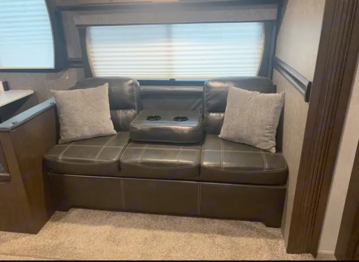 Enjoy comfortable seating in this RV rental! Features a sofa with cupholders & throw pillows.. Heartland Pioneer 2020