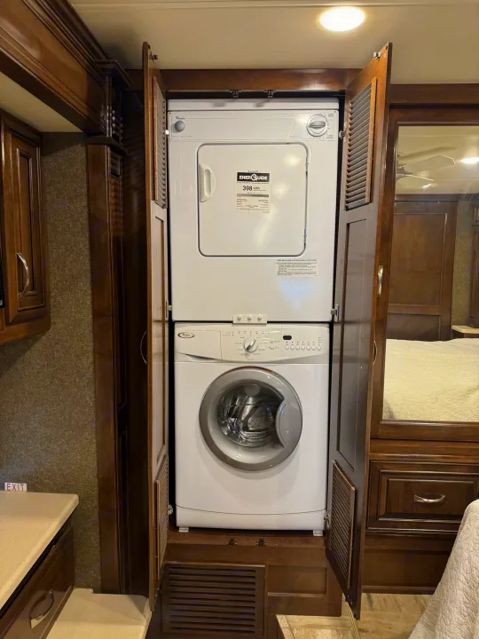 Enjoy laundry on the go! This RV rental features a compact Whirlpool stacked washer/dryer unit in custom cabinetry.. Thor Venetian 2017