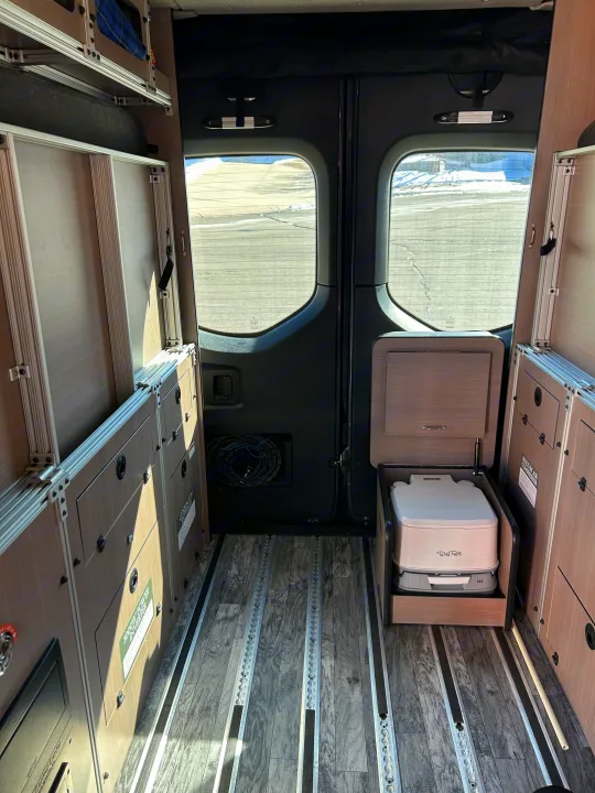 Inside this RV rental, modular storage, L-track floor, and a hidden portable toilet create a compact camper van setup.. Antero Adventure Motors Antero Adventure Motors Class B 2022