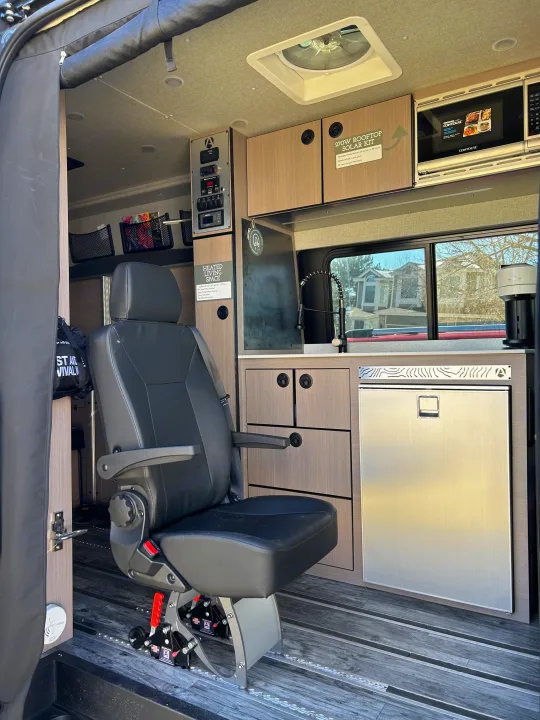 Spacious RV rental interior with swiveling seat, compact kitchen, and storage, perfect for adventure travel. Note the solar kit info.. Antero Adventure Motors Antero Adventure Motors Class B 2022