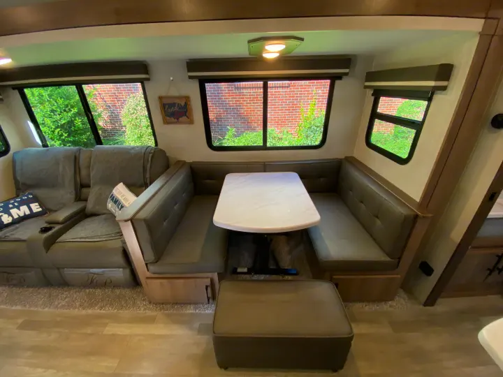 Explore this RV rental's comfy dinette area and reclining seats. Large windows offer views, bright overhead lights illuminate the space.. Grand Design Imagine 2023
