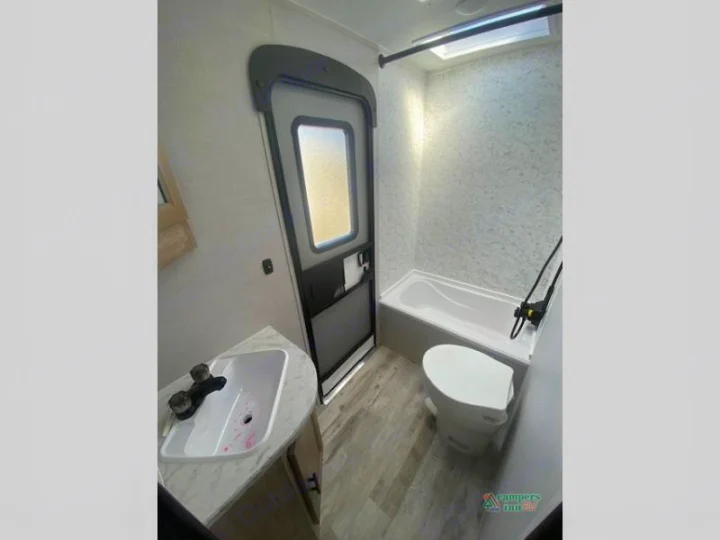 Explore this RV rental's compact bathroom, featuring a sink, toilet, and bathtub/shower combo for your travel comfort.. Gulf Stream Friendship 268BH 2024