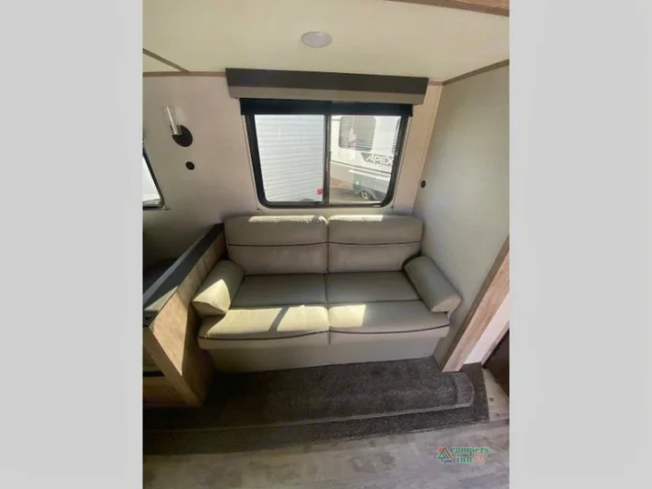 RV rental interior: light-colored sofa in a bright living area with a large window.. Gulf Stream Friendship 268BH 2024