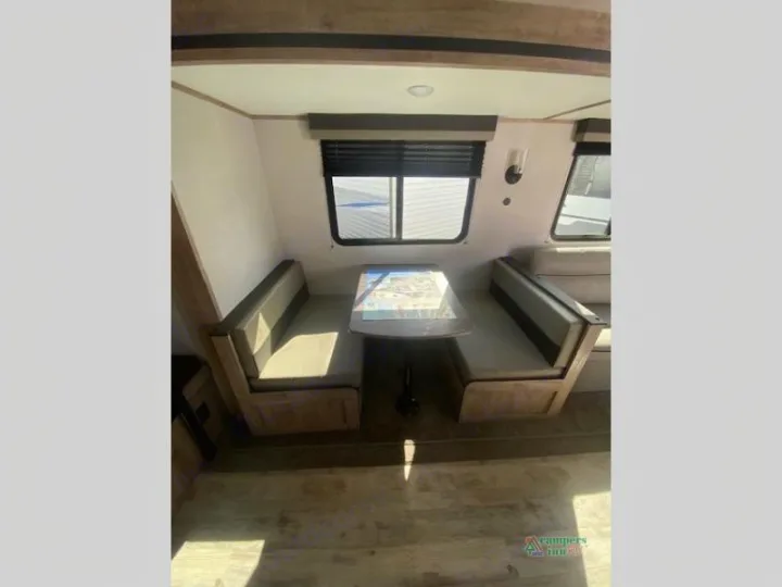 Cozy RV rental dinette with comfortable benches and a table, perfect for meals on the go.. Gulf Stream Friendship 268BH 2024