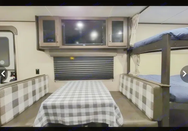Cozy RV rental interior featuring a dining area, TV, and bunk beds, perfect for family travel.. Grand Design Other 2022