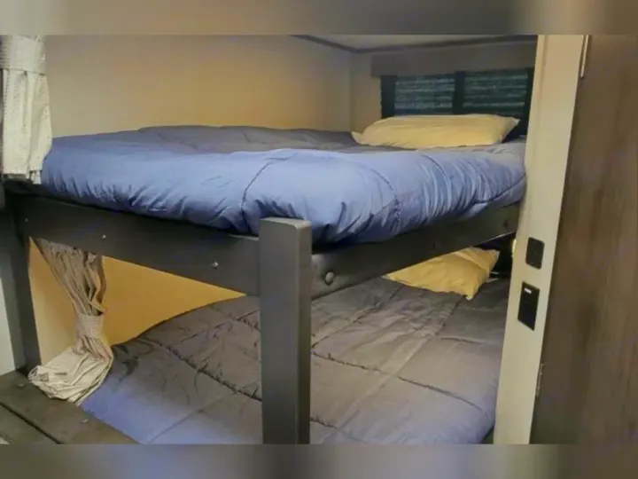 RV rental: Interior shows stacked bunk beds with blue and grey bedding, a compact sleeping solution.. Grand Design Other 2022