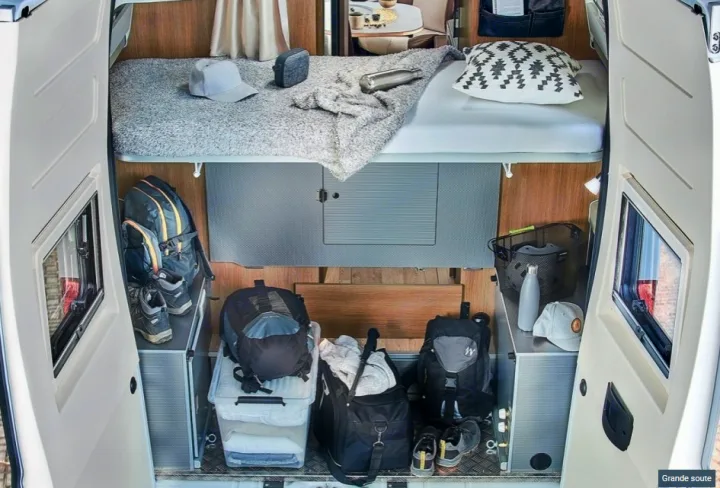 RV rental camper's rear interior: compact bed above organized storage for travel gear & essentials.. CAMPEREVE FAMILY VAN 2022