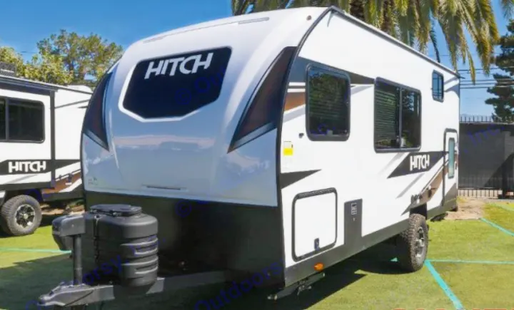 A sleek white and black HITCH travel trailer, ideal for rv rental. Parked on green grass, ready for adventure.. Cruiser RV Hitch 2024