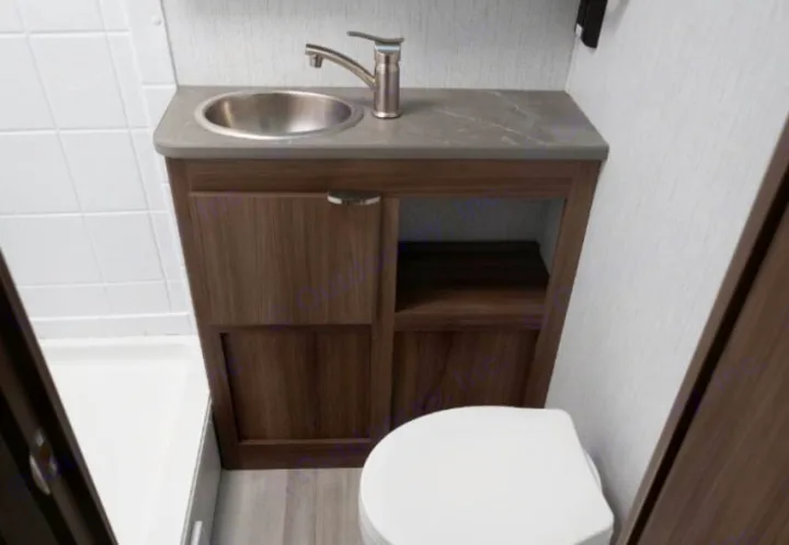 Compact RV rental bathroom showcasing a vanity, sink, toilet, and part of the shower area.. Cruiser RV Hitch 2024