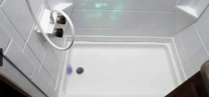 RV rental shower: a compact, clean white shower stall with a drain and water controls, ideal for an RV.. Cruiser RV Hitch 2024