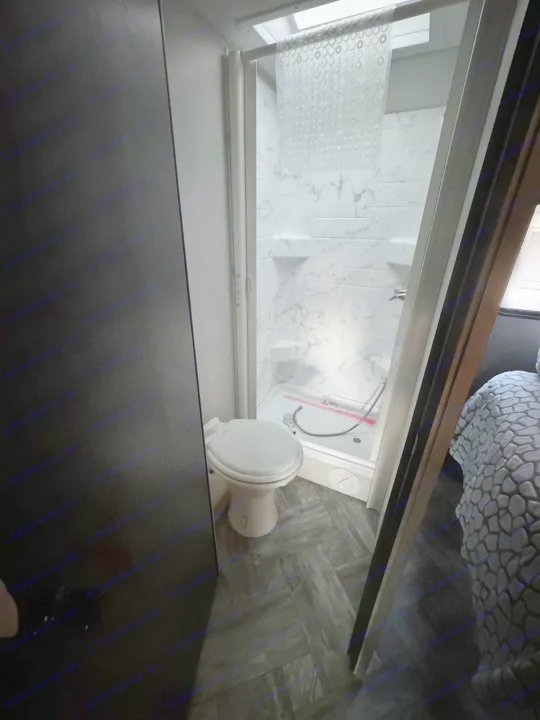 This rv rental features a compact bathroom with a toilet and marble-look shower, a practical space for travel.. Forest River Sunseeker LE 2022