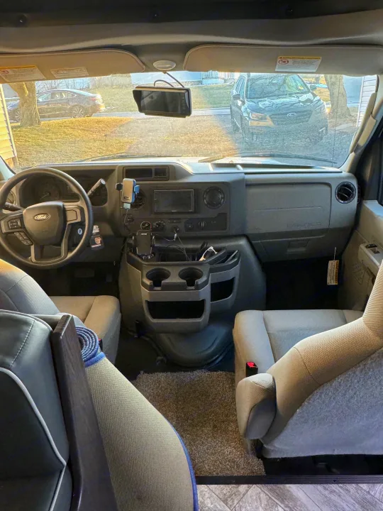 Inside an rv rental: driver's cockpit view with dashboard, steering wheel, and front seats.. Forest River Sunseeker LE 2022