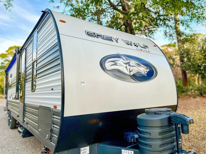 Grey Wolf Limited travel trailer, featuring its wolf logo, available for rv rental. Perfect for your next camping trip in the outdoors.. Forest River Cherokee Grey Wolf 2024