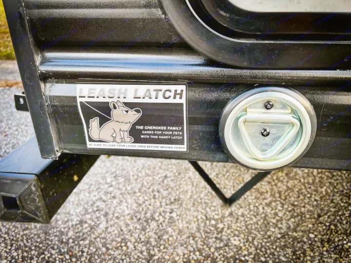 RV rental shows a "Leash Latch" sticker with a cartoon dog and D-ring for pet safety on the travel trailer side.. Forest River Cherokee Grey Wolf 2024