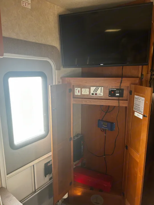 RV rental interior: View of entertainment and essential controls (generator, solar, water) in an open cabinet next to the exit.. Adventurer Adventurer Motorhome 2012