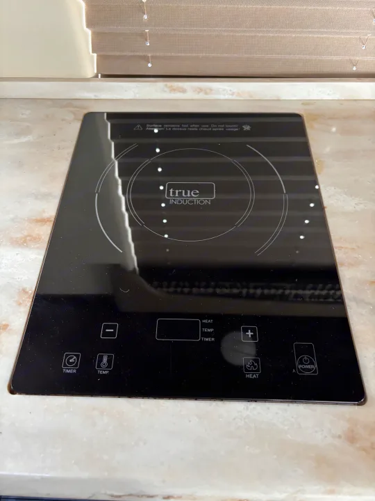 Modern True Induction cooktop, ideal for an RV rental kitchen, featuring sleek touch controls for versatile cooking.. Mercedes-Benz Sprinter RV Motorhome Campervan 2017