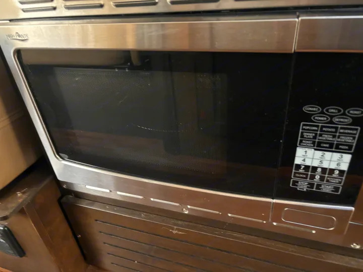 Compact stainless steel High Pointe microwave, ideal for an RV rental, featuring a convection oven and full control panel.. Mercedes-Benz Sprinter RV Motorhome Campervan 2017