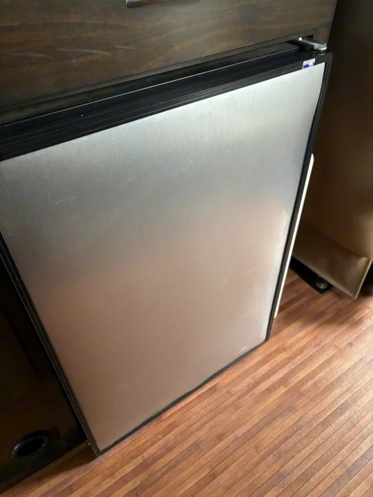 Compact Norcold stainless steel refrigerator with minor scratches in an RV rental for your travels.. Mercedes-Benz Sprinter RV Motorhome Campervan 2017
