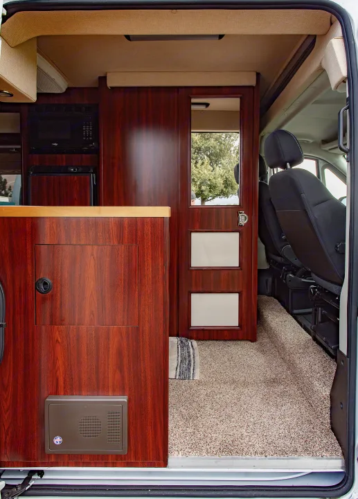 Step inside this inviting RV rental. Features dark wood cabinetry, compact kitchen appliances, and comfortable carpeted living space.. Dodge Promaster 2500 2014