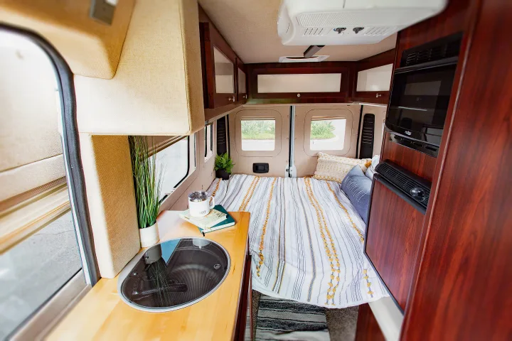 Cozy rv rental camper van interior: comfortable bed, compact kitchen, and amenities for travel.. Dodge Promaster 2500 2014