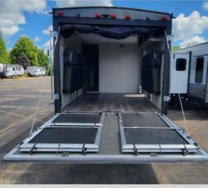 Spacious toy hauler RV rental: ramp door lowered, revealing versatile cargo area with fold-up beds. Perfect for your adventures.. Coachmen Catalina 2022