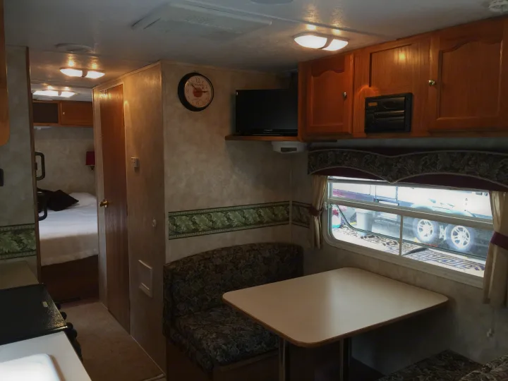 RV rental interior: dinette, kitchen counter, and bedroom. A comfortable space for travel.. Keystone RV Springdale 2005