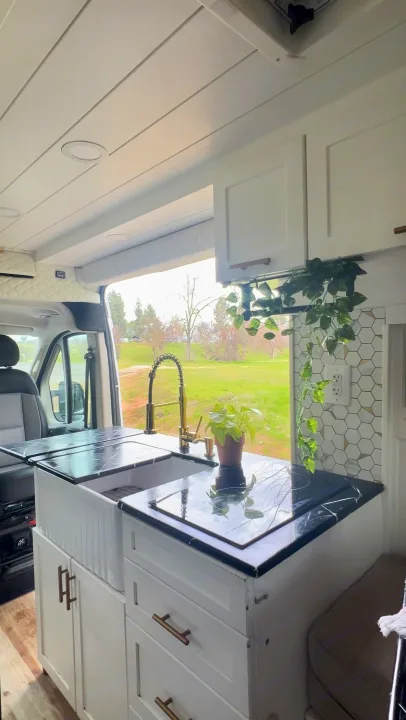This RV rental kitchen features a modern sink, cooktop, and ample storage for comfortable mobile living.. Dodge Ram 1500 2019