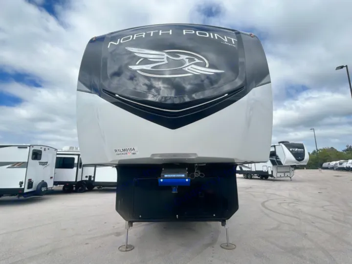 A large, sleek white and black North Point fifth-wheel RV on a sales lot. Consider this for your next rv rental!. Keystone RV Jayco northpoint 2026