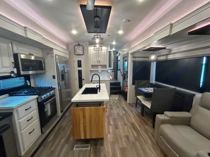 Spacious RV rental interior: modern kitchen, dining booth, and living area with light wood floors.. Keystone RV Jayco northpoint 2026