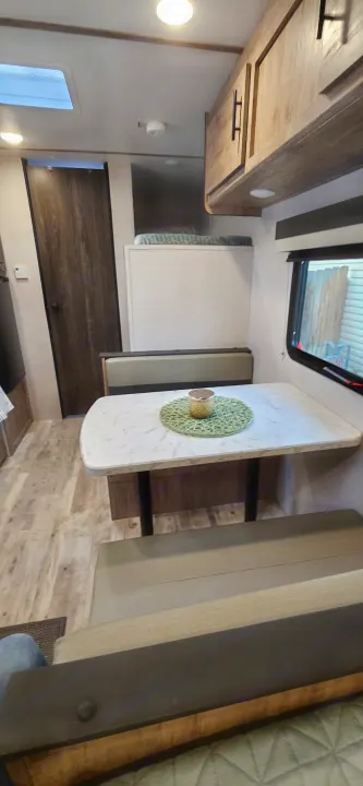 Spacious RV rental interior featuring a dinette, overhead cabinets, and bunk bed, perfect for travel comfort.. Gulf Stream Ameri-Lite LE 2023