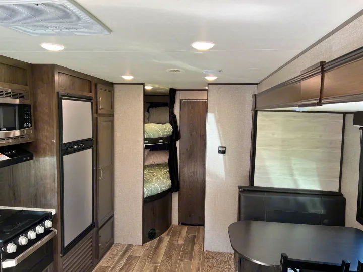 Spacious and modern RV rental interior featuring a full kitchen, comfortable bunk beds, and a cozy dinette area.. Jayco Jay Flight SLX 2021