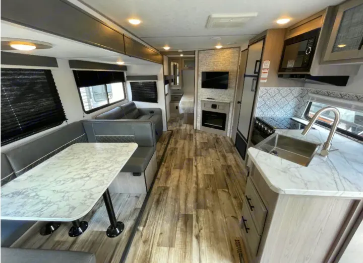 Spacious RV rental interior featuring a modern kitchen, comfortable dinette, and cozy living area.. Dutchmen Coleman Light 2023