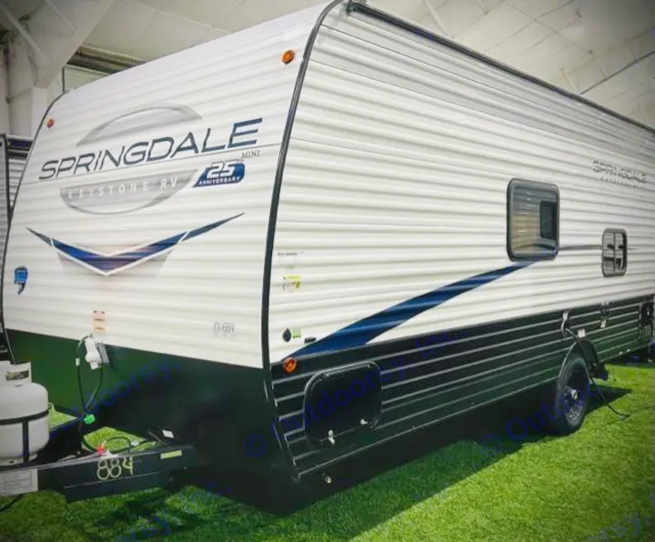 New Springdale Mini travel trailer RV rental (Keystone RV) in white & black, displayed on green turf.. Keystone RV Springdale Mini 1800BH 2024