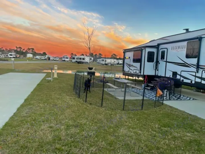 Scenic RV park at sunset. This RV rental site includes a pet area & concrete pad. Perfect for camping.. Forest River Rockwood Ultra Lite 2022