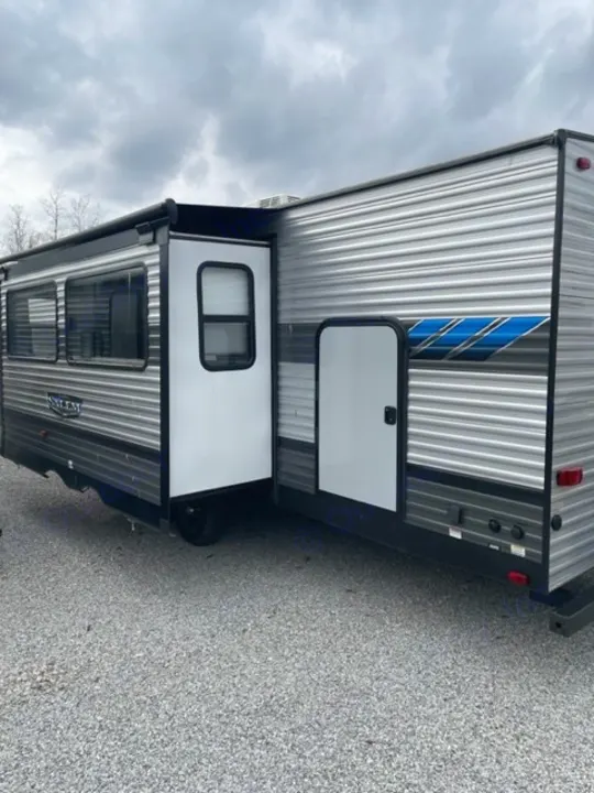 Explore the open road! This sleek gray travel trailer, great for an rv rental, features an open door & extended awning.. salem 29VBUD 2022