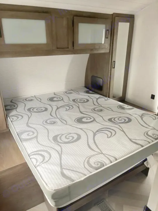 RV rental bedroom with bed, overhead cabinets, and mirrored closet. Perfect for a restful journey.. salem 29VBUD 2022