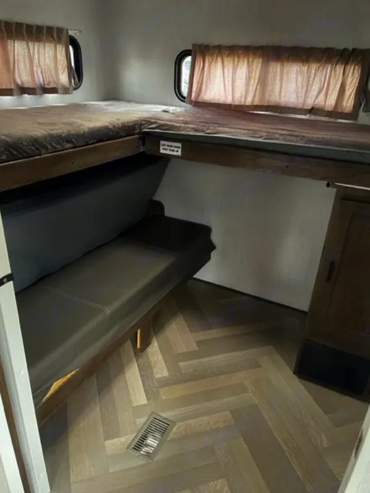 Cozy RV rental bunk beds with convertible sofa area, perfect for family adventures. Light herringbone flooring.. salem 29VBUD 2022
