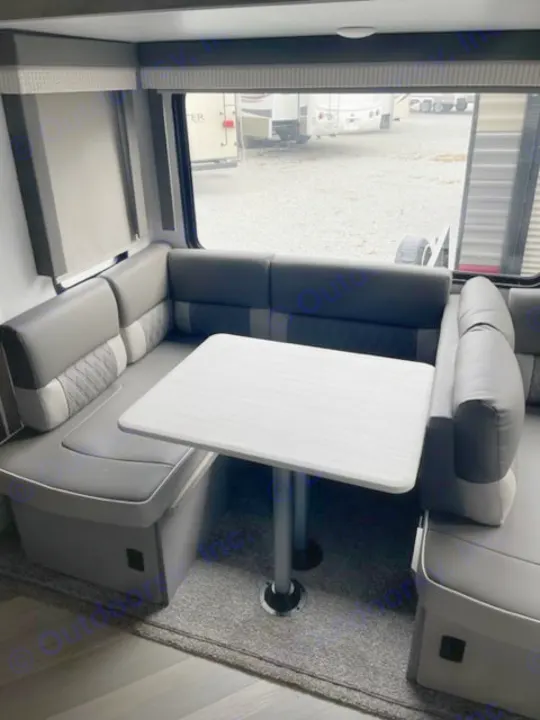 RV rental dinette with comfortable U-shaped seating, central table, and large window view.. salem 29VBUD 2022