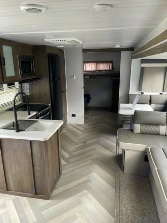 Bright RV rental interior showing a kitchen, living space, and rear bunk beds for travel comfort.. salem 29VBUD 2022