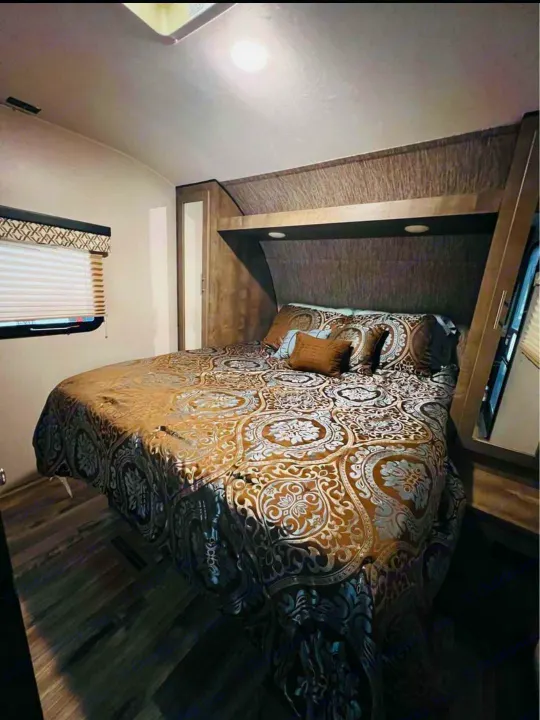 Cozy RV rental bedroom with patterned bedding & built-in storage. Ideal for travel comfort.. KZ Connect 2019